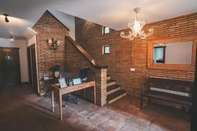 a room with a brick wall with a staircase and a desk at HolaCamp Camino in O Pino
