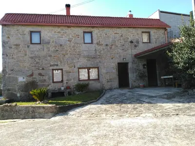 a stone house with a driveway in front of it at Casa dos Eiriz in Souto