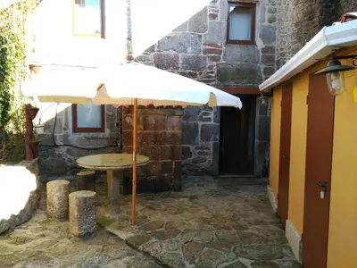 a table with an umbrella in front of a building at Casa dos Eiriz in Souto