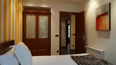 a bedroom with a bed and a wooden door at Apartamentos Lagos de Saliencia in Saliencia