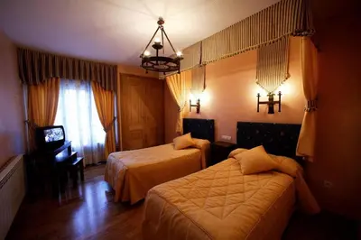 a hotel room with two beds and a television at Posada Real La Yensula in El Puente