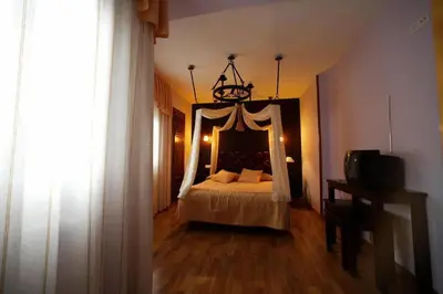 a bedroom with a bed and a chandelier at Posada Real La Yensula in El Puente