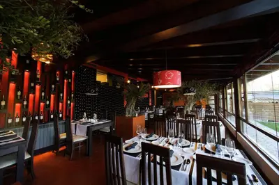 a restaurant with tables and chairs and a red chandelier at Posada Real La Yensula in El Puente