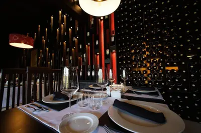 a table in a wine cellar with plates and wine glasses at Posada Real La Yensula in El Puente