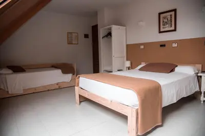 a bedroom with two beds in a room at Hotel Los Olmos in Lugo