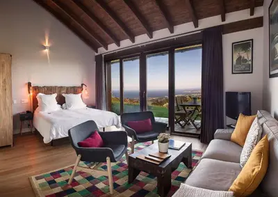 a bedroom with a bed and a living room with a couch at Hotel Rural 3 Cabos in El Vallin