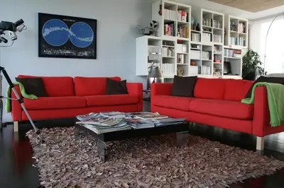 a living room with two red couches and a coffee table at Hotel Rural 3 Cabos in El Vallin