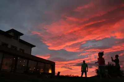 a group of people flying a kite at sunset at Hotel Rural 3 Cabos in El Vallin