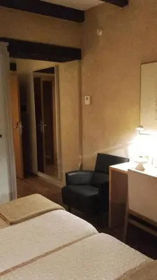 a hotel room with a bed and a chair and a couch at Posada Real de Las Misas in Puebla de Sanabria