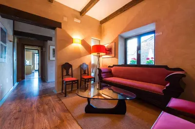 a living room with a red couch and a table at Posada Real de Las Misas in Puebla de Sanabria