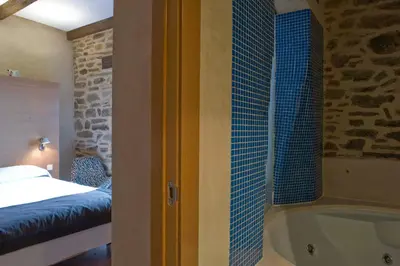 a bedroom with a bed and a tub in a room at Posada Real de Las Misas in Puebla de Sanabria