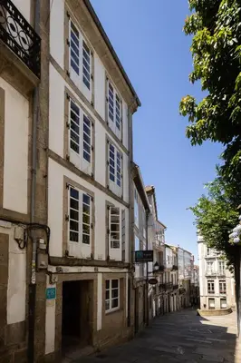 an alley in an old building with white windows at PR Badalada in Santiago de Compostela
