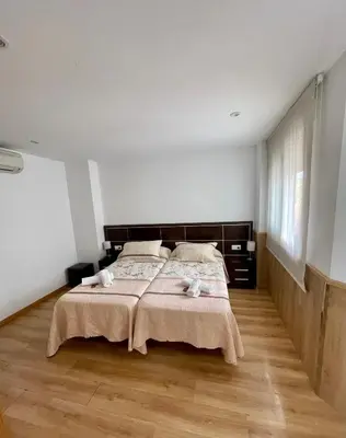 a bedroom with a bed with two towels on it at Pension Orois in Melide