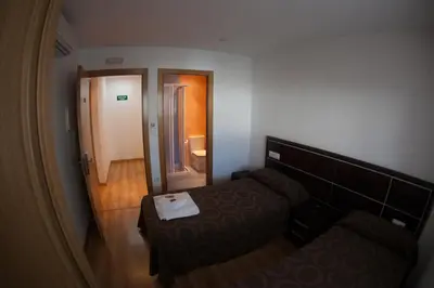 a view of a room with a bed and a mirror at Pension Orois in Melide