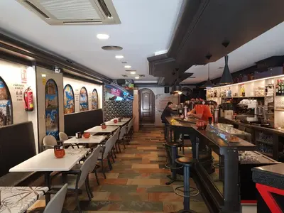 a dining room with tables and a bar at Pension Orois in Melide