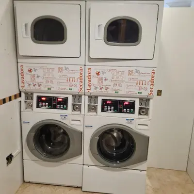 four washing machines are in a laundry room at Pension Orois in Melide