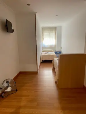 a room with a bedroom with a bed and a window at Pension Orois in Melide