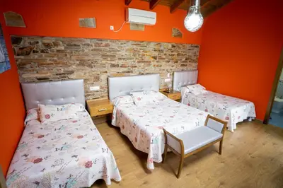 two beds in a room with orange walls at El Pinar in Ribadeo