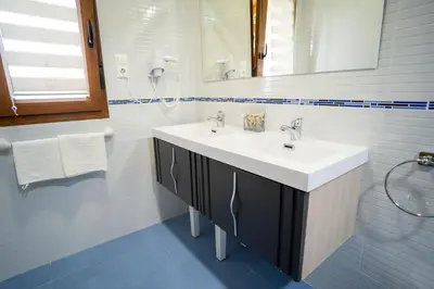 a white bathroom with a sink and a mirror at El Pinar in Ribadeo