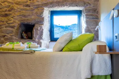 a bedroom with a large bed with a window at Casa Costiña in Cotobade