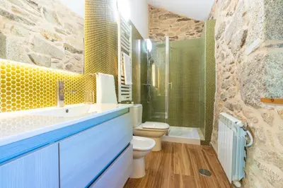a bathroom with a sink and a toilet and a shower at Casa Costiña in Cotobade