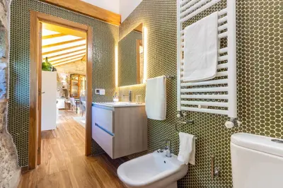 a bathroom with a sink and a toilet and a mirror at Casa Costiña in Cotobade