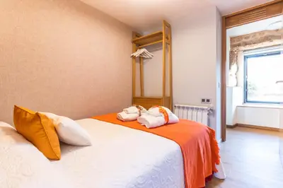 a bedroom with two beds with orange and white pillows at Casa Costiña in Cotobade