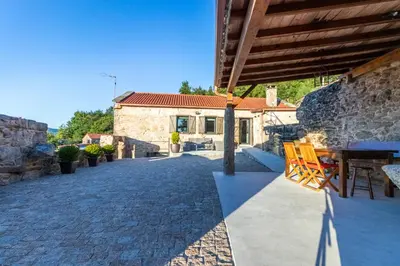 a patio with a table and chairs and a building at Casa Costiña in Cotobade