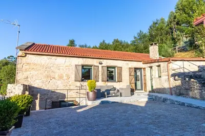 a stone house with a patio in front of it at Casa Costiña in Cotobade
