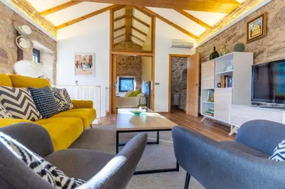 a living room with a yellow couch and chairs at Casa Costiña in Cotobade
