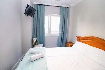 a bedroom with a bed with a television and a window at Pensión Caldas in Caldas de Reis