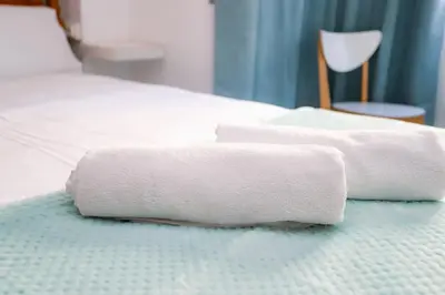 a white towel is laying on a bed at Pensión Caldas in Caldas de Reis