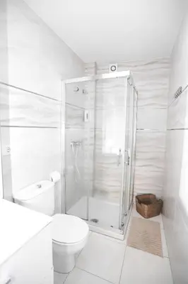 a white bathroom with a shower and a toilet at Pensión Caldas in Caldas de Reis