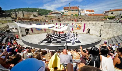 a crowd of people watching a band performing on a stage at Loft Medieval in Ribadavia