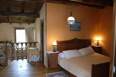 a bedroom with a bed and two lamps and a balcony at Complejo rural Aira Sacra-Ribeira Sacra in Vilamelle