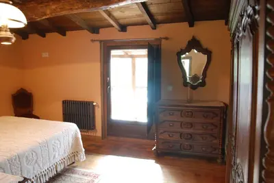 a bedroom with a bed and a dresser and a window at Complejo rural Aira Sacra-Ribeira Sacra in Vilamelle