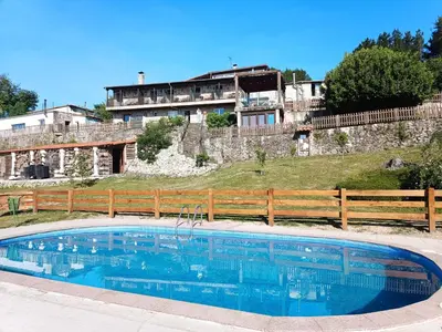 a large swimming pool in front of a building at Casa dos Muros turismo rural y actividades en la Ribeira Sacra in Pantón