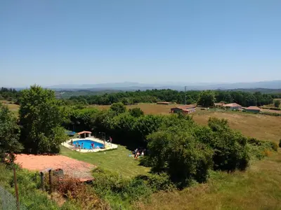 a group of people standing around a pool in a field at Casa dos Muros turismo rural y actividades en la Ribeira Sacra in Pantón
