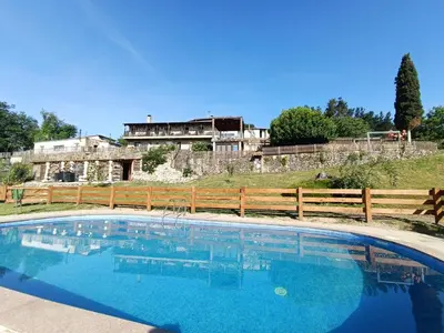 a large swimming pool in front of a house at Casa dos Muros turismo rural y actividades en la Ribeira Sacra in Pantón