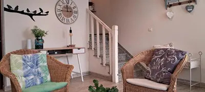 a living room with two chairs and a clock on the wall at Casa fonte da pena in Rinlo