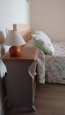 a table with a lamp on it next to a bed at Casa fonte da pena in Rinlo