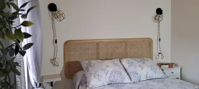 a bed with a wooden headboard in a bedroom at Casa fonte da pena in Rinlo