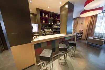 a bar with chairs and a counter in a room at Hotel Aroi Ponferrada in Ponferrada