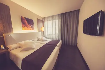 a hotel room with a bed and a television at Hotel Aroi Ponferrada in Ponferrada
