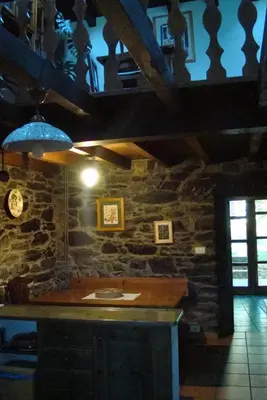 a kitchen with a counter and a stone wall at Casa dos Pedrouzos in Doncos