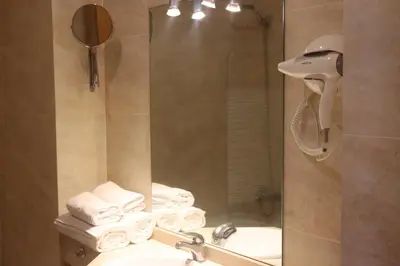 a bathroom with a sink and a shower with towels at Hotel Balcón de San Bartolo in Barreiros
