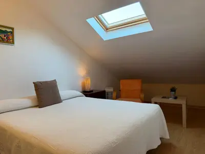 a bedroom with a white bed and a skylight at Hotel Balcón de San Bartolo in Barreiros
