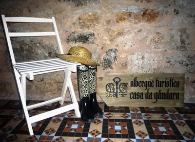 a hat sitting on a stool next to a chair at Albergue-Hostel Casa da Gandara in Boimorto