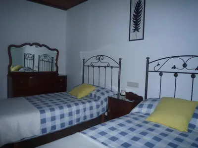 a bedroom with two beds and a mirror on the wall at Albergue-Hostel Casa da Gandara in Boimorto