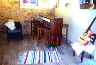 a living room with a wooden table and a guitar at Albergue-Hostel Casa da Gandara in Boimorto